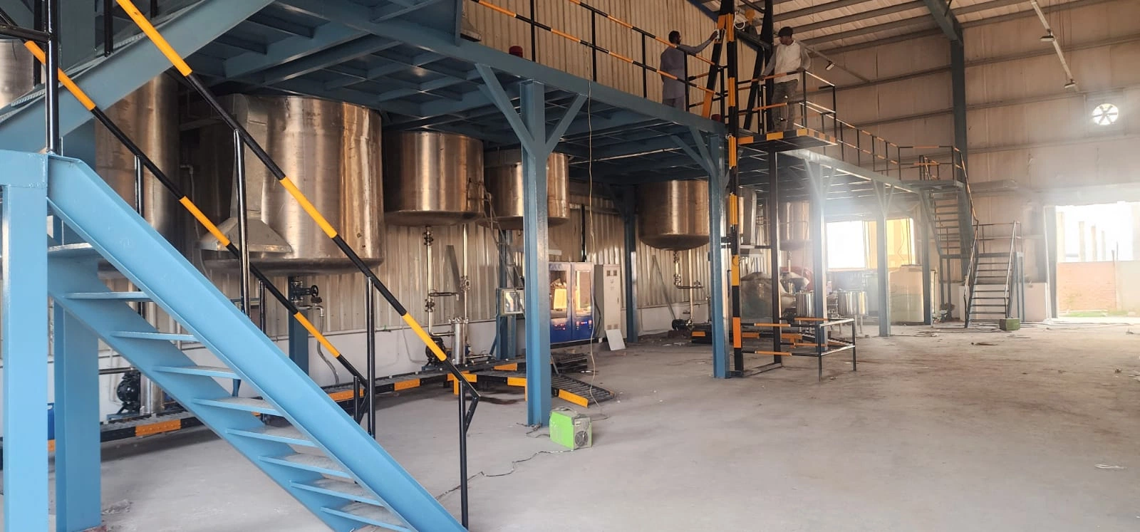 Steel Tech Engineering production floor interior with stainless steel mixing tanks and mezzanine platform